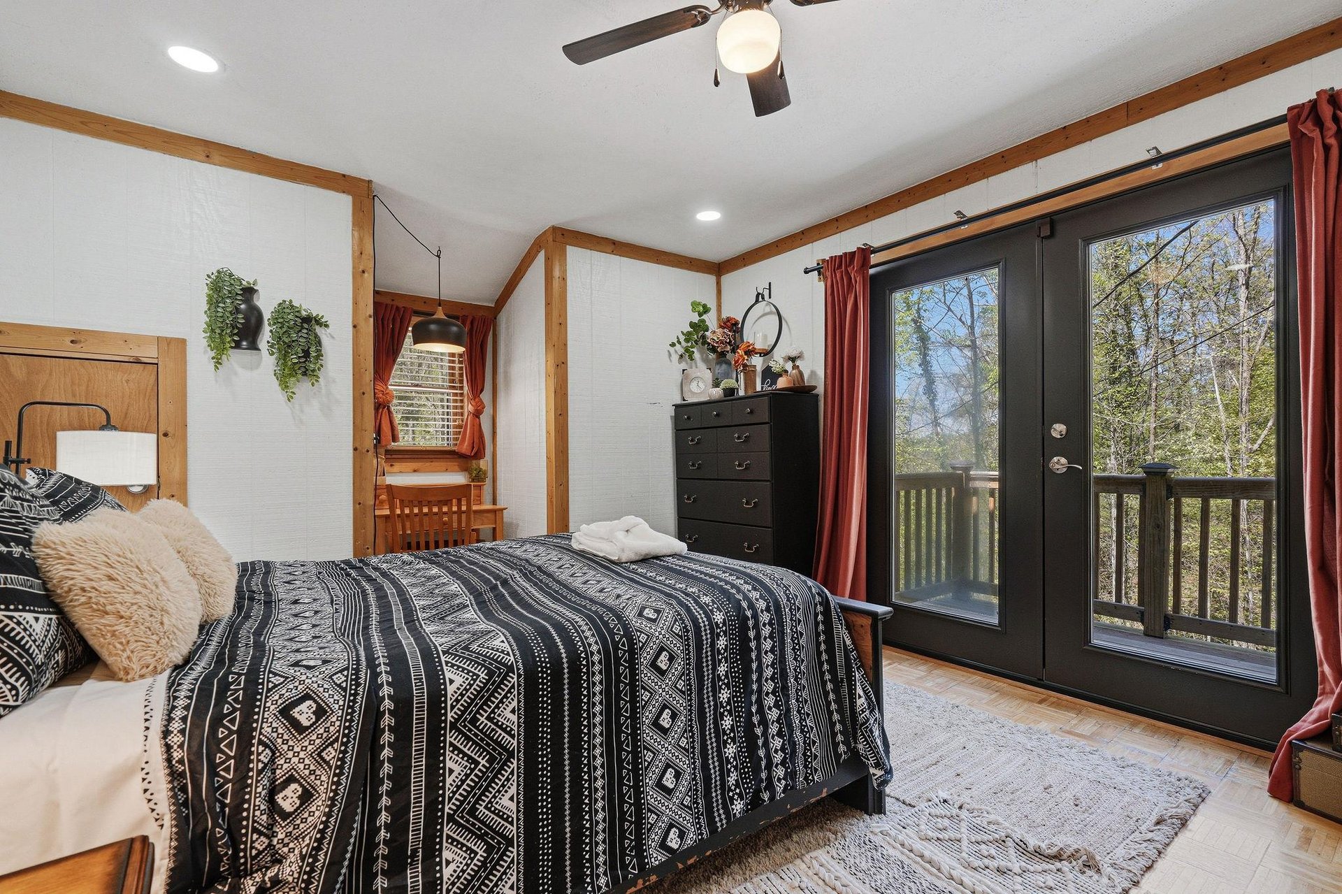 Wake up in your cozy bedroom where natural wood beams frame peaceful forest views through French doors leading to your private balcony.