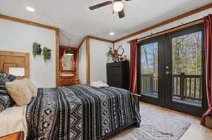 Wake up in your cozy bedroom where natural wood beams frame peaceful forest views through French doors leading to your private balcony.