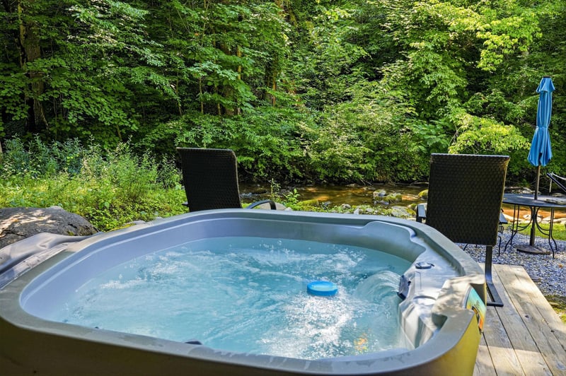 Soak in your private hot tub while listening to the gentle babble of the stream flowing just steps away, surrounded by lush forest greenery.