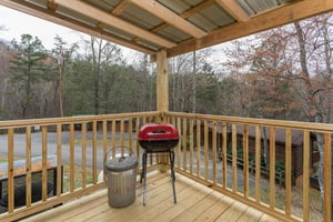 Charcoal grill on a covered deck at Boogie Bear, a 1bedroom cabin rental located in Gatlinburg