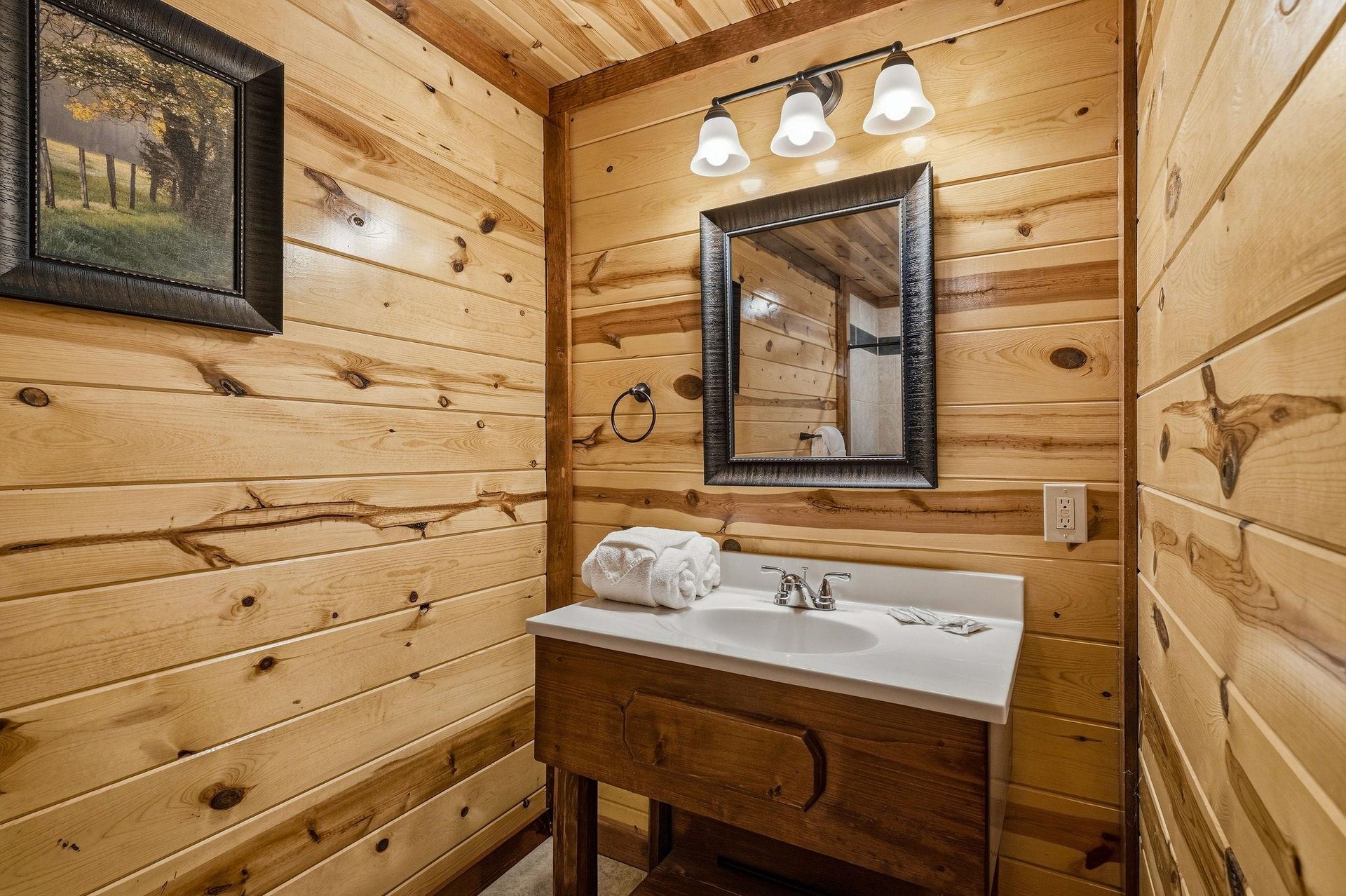 Freshen up in your rustic log bathroom, where warm wood walls and soft lighting create a cozy cabin retreat.