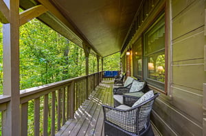Your private covered balcony offers forest views and cozy wicker seating where you can sip morning coffee surrounded by natures tranquility.