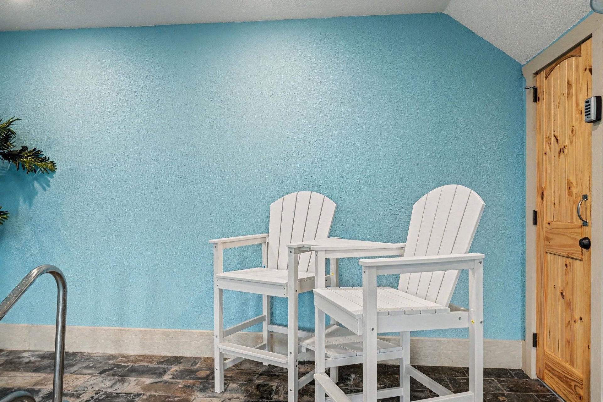 Relax in your private seating nook with comfortable white chairs against soothing turquoise walls—perfect for morning coffee or quiet conversations.