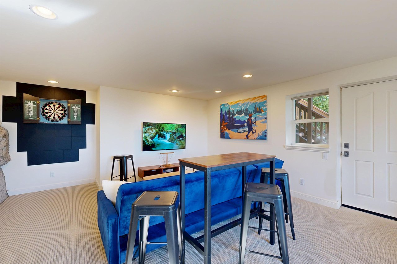 Smart TV, shuffleboard, darts, deck access, and a sofa pullout twin bed.