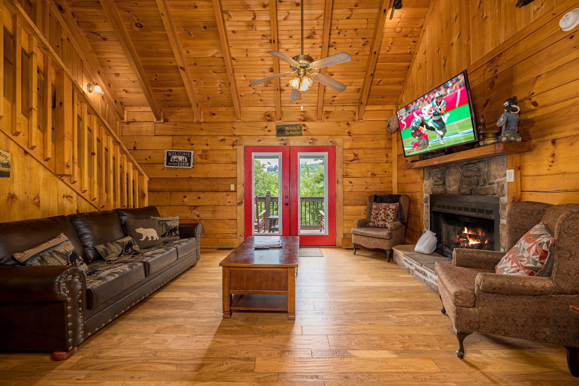 Living room with stone fireplace and red doors to deck