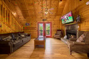 Living room with stone fireplace and red doors to deck