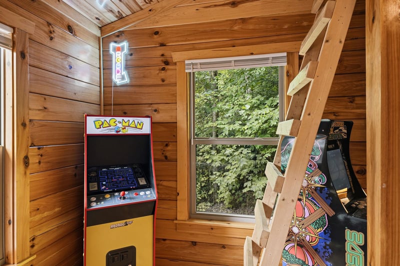 Relive classic arcade fun in this cozy wooden game room where warm pine walls and lush greenery views surround your play.