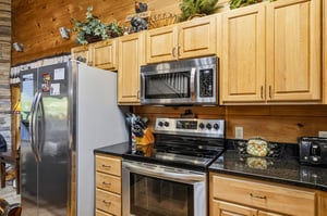 Your fullyequipped mountain kitchen features warm wood cabinetry, granite counters, and stainless steel appliances—perfect for preparing hearty meals.