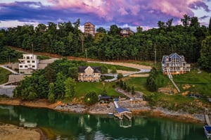 Lakefront vacation homes nestled among forested hills, featuring private docks and stunning panoramic views of the water and surrounding natural landscape.