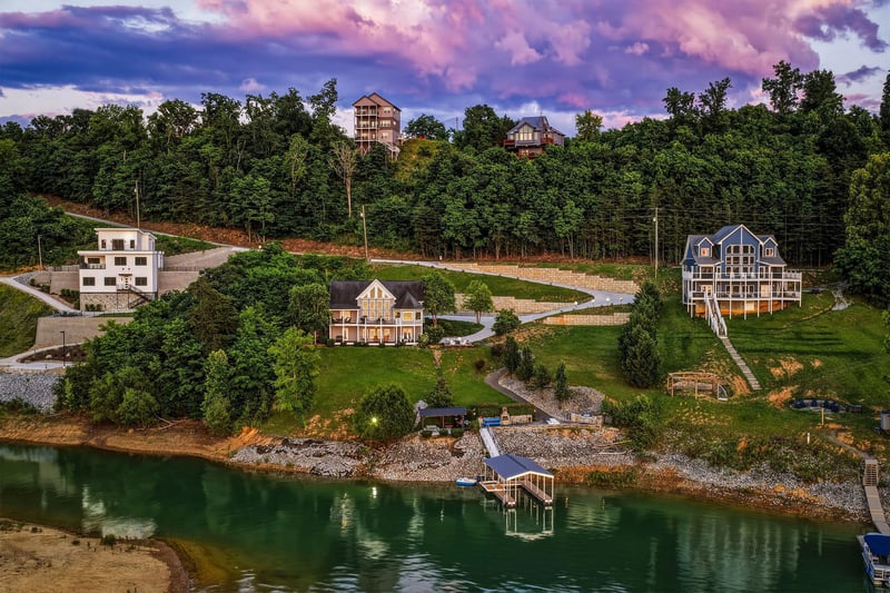 Lakefront vacation homes nestled among forested hills, featuring private docks and stunning panoramic views of the water and surrounding natural landscape.