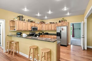 Your fullyequipped kitchen features rich oak cabinetry, granite countertops, and a breakfast bar perfect for morning coffee or casual meals with loved ones.