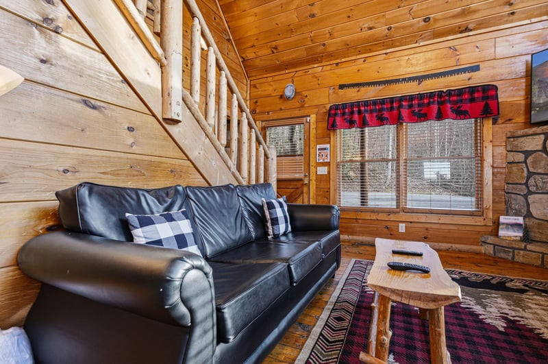 Cozy up by the stone fireplace in your rustic living room, where warm wood surrounds you and plaid touches create the perfect mountain retreat.