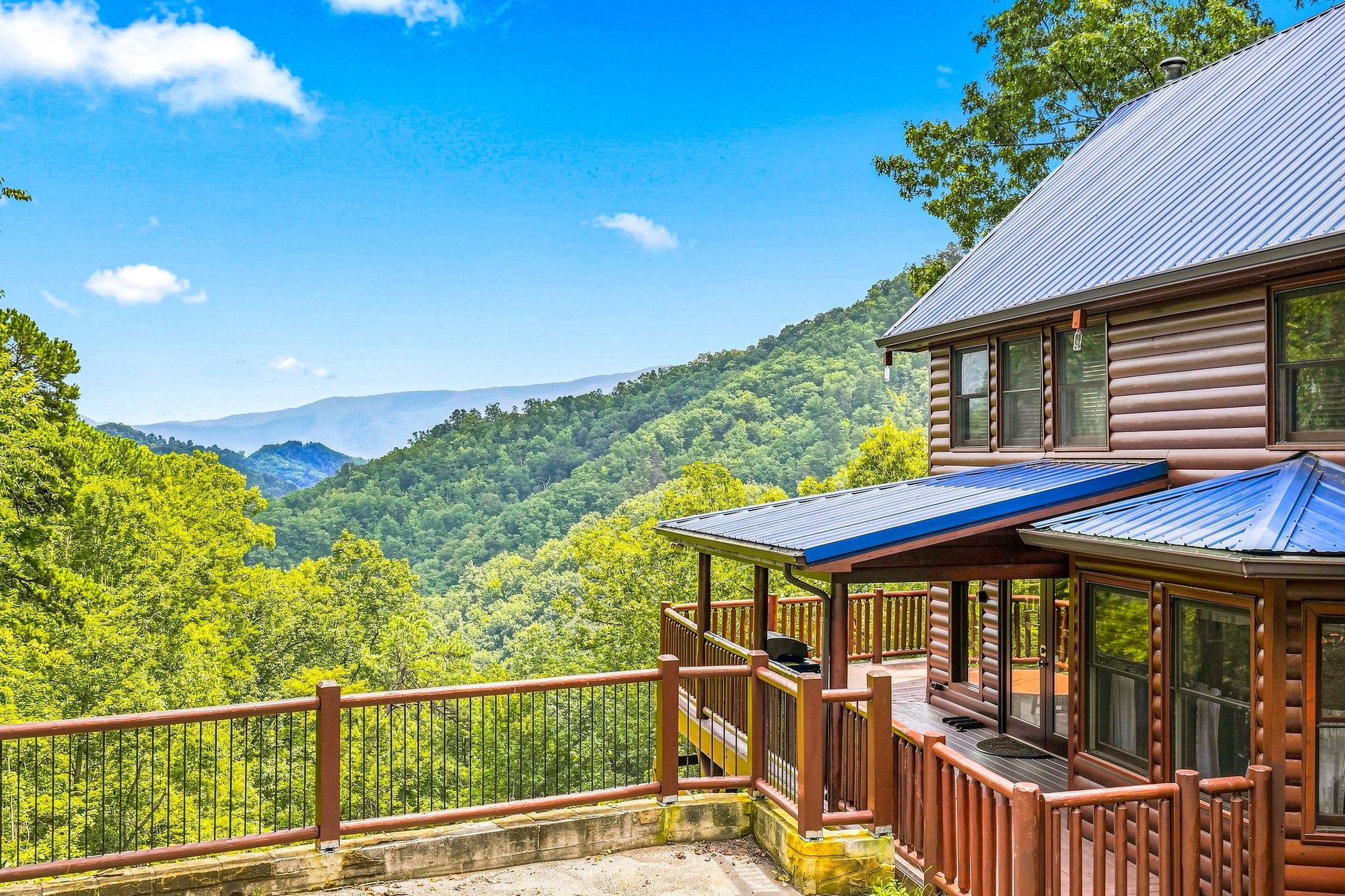Your private mountain retreat features a spacious deck where you can soak in sweeping views of lush, rolling peaks under open skies.
