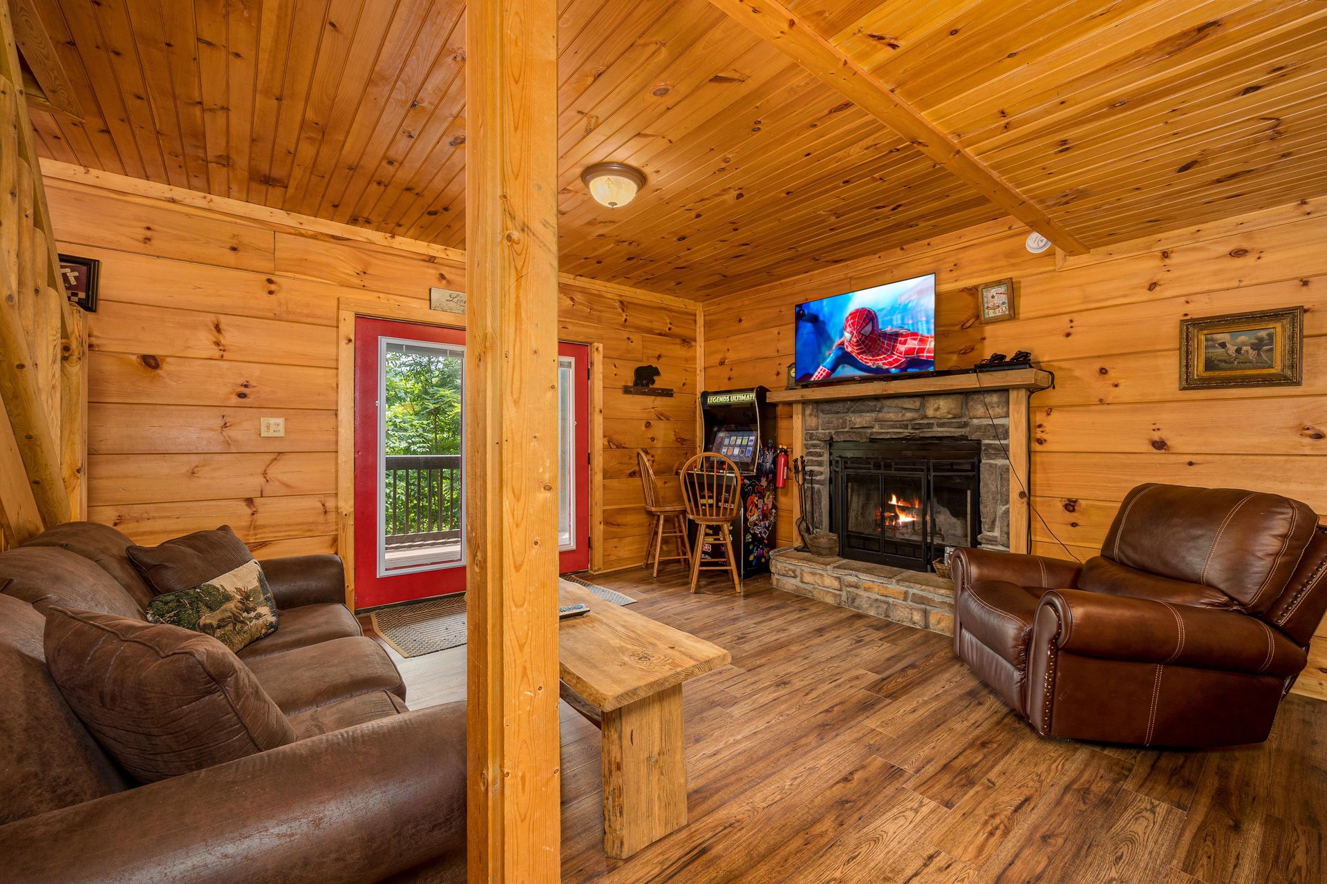 Seating area with arcade game and stone fireplace
