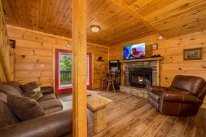 Seating area with arcade game and stone fireplace
