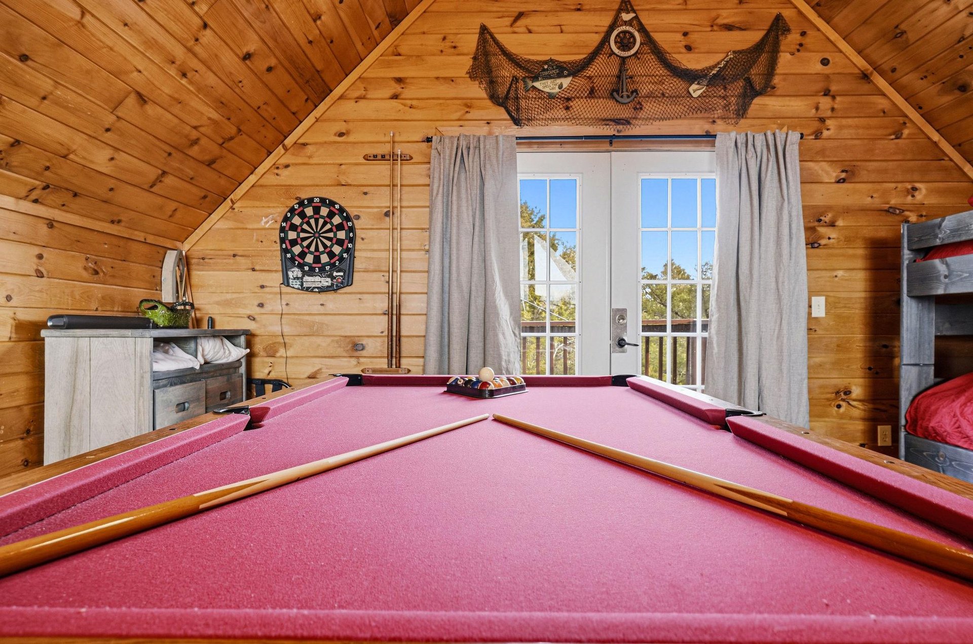 Your own private game room awaits with a fullsize pool table, dartboard, and cozy cabin charm for endless entertainment.