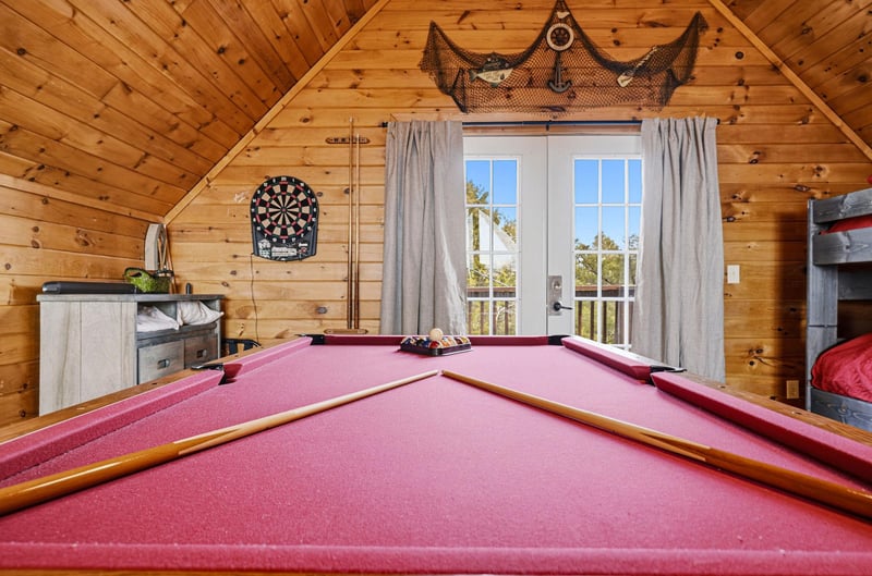 Your own private game room awaits with a fullsize pool table, dartboard, and cozy cabin charm for endless entertainment.
