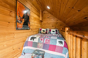 Retreat to your cozy loft bedroom, wrapped in warm knotty pine and topped with a charming quilt—perfect for unwinding after your mountain adventures.