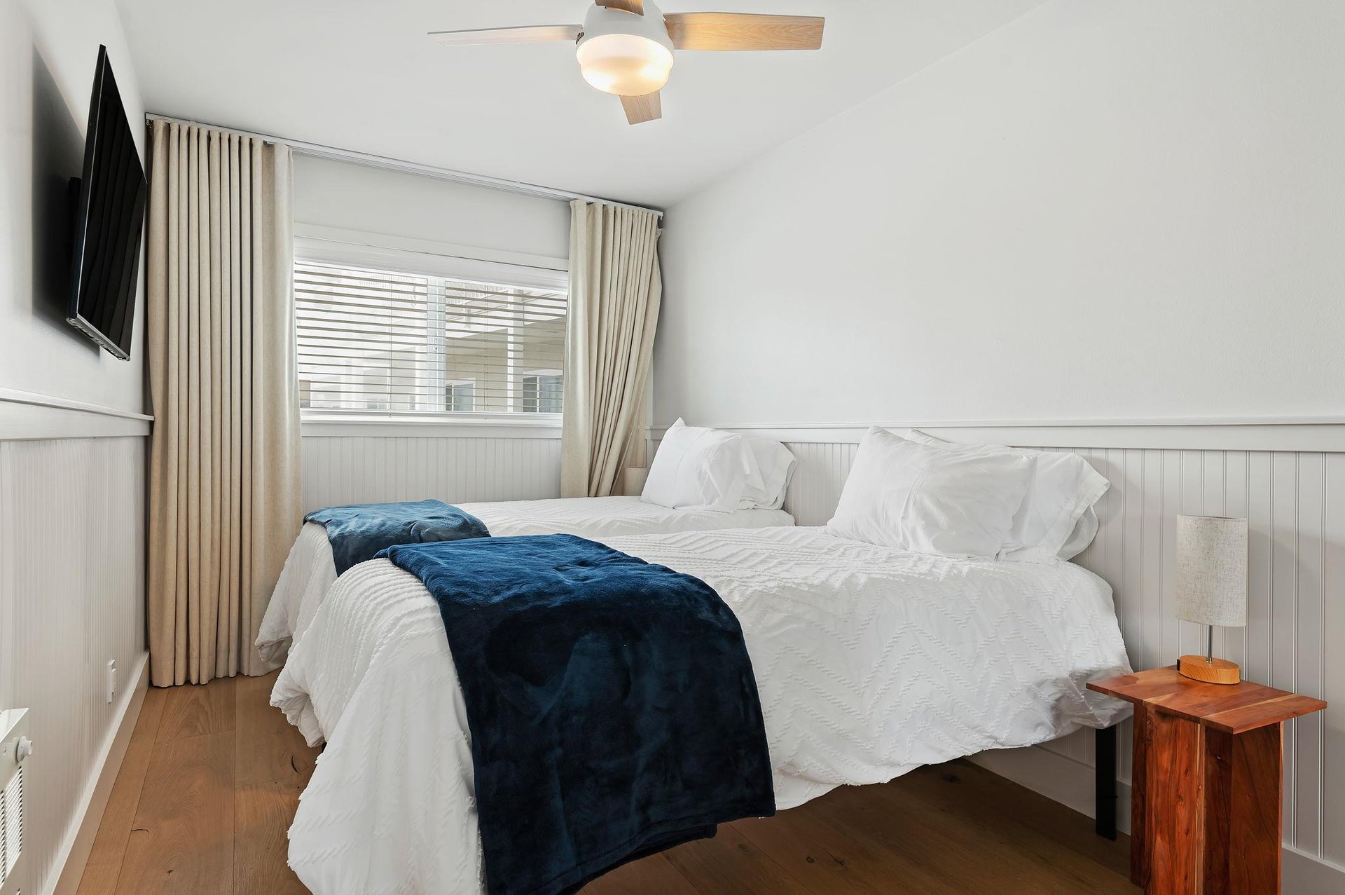 The second bedroom also has shades, curtains, ceiling fan and flatscreen TV.