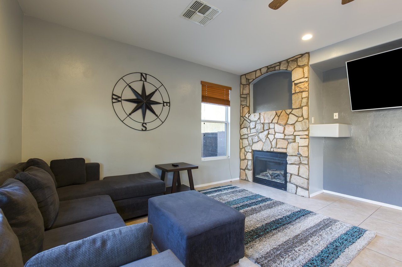 Cozy sectional couch, gas fireplace, and flatscreen TV that is also viewable from the dining area.