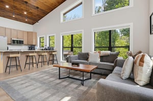 Sink into plush seating beneath soaring vaulted ceilings while natural light pours through floortoceiling windows framing lush greenery. An openconcept layout connects you to the modern kitchen, pe