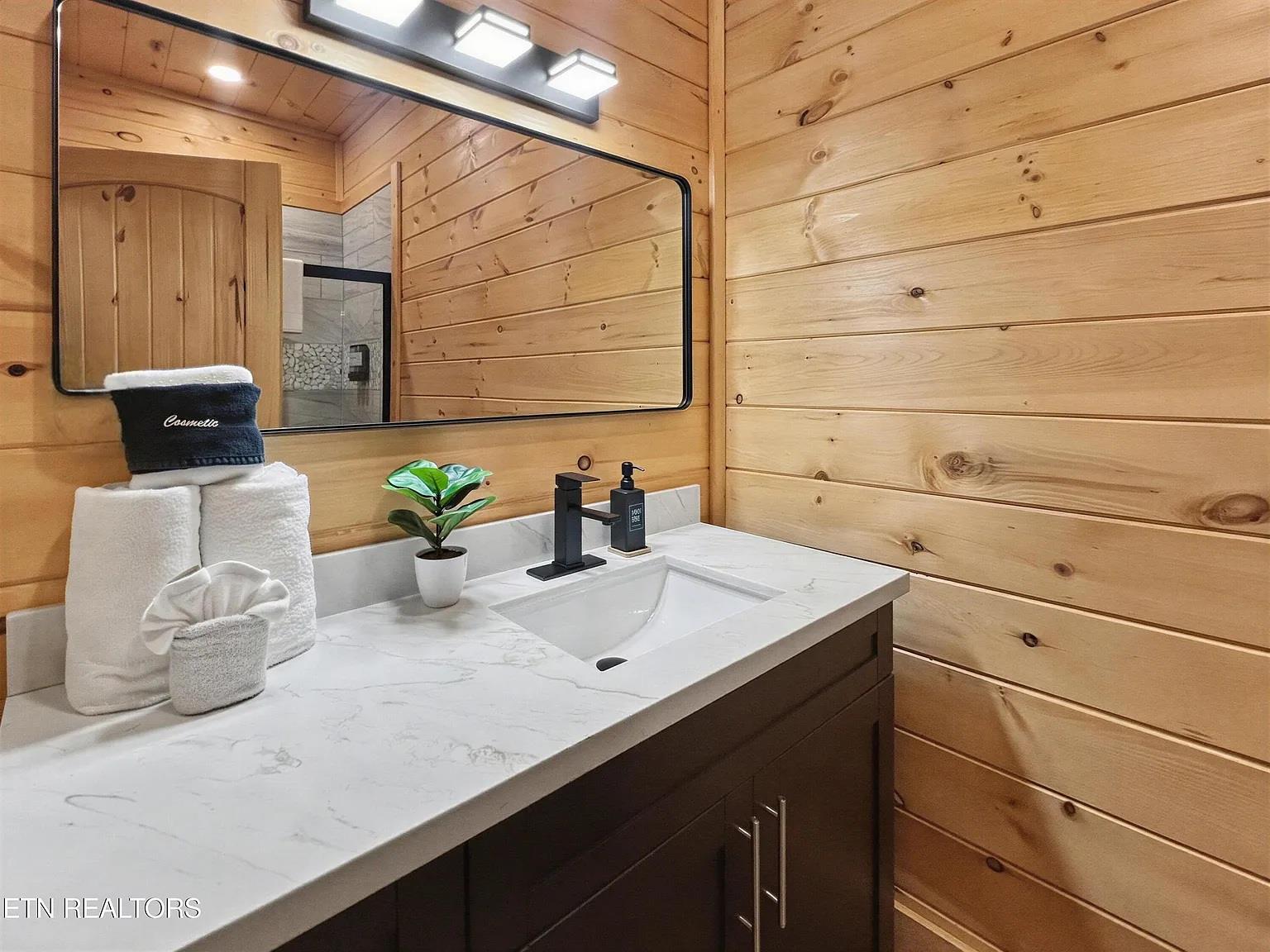 Unwind in your private spainspired bathroom featuring warm wood walls and elegant marble countertops with thoughtful amenities.