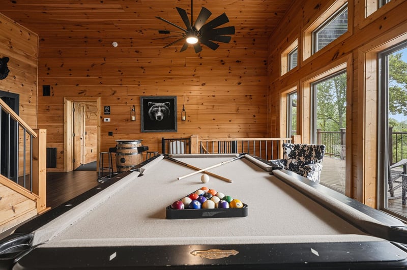 Gather around for a friendly game of pool in this stunning woodpaneled game room, where natural light and mountain views create the perfect backdrop for your vacation fun.