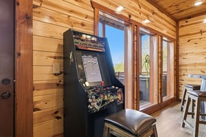 Challenge friends to classic arcade games in your cozy cabin retreat, where warm wood walls and mountain views create the perfect gaming atmosphere.