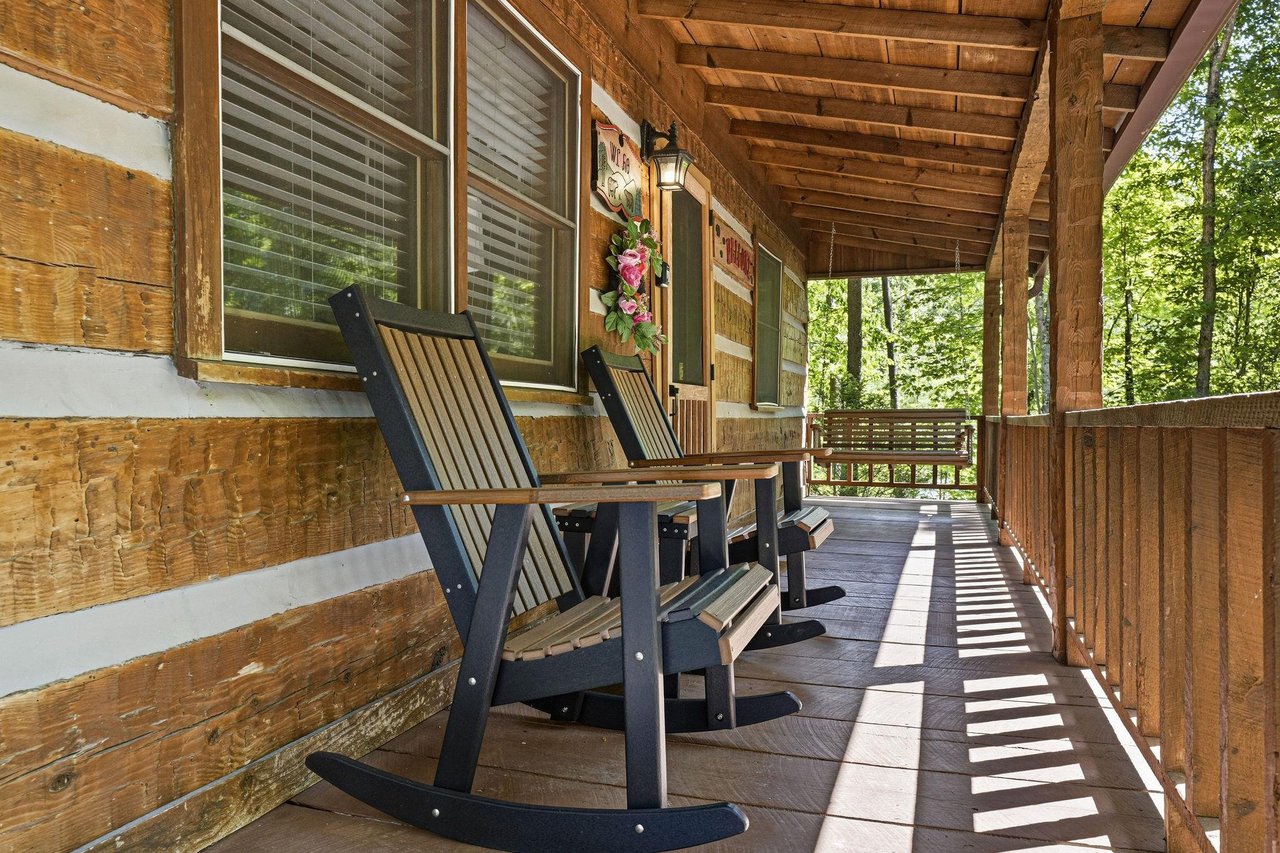 Picture yourself rocking gently in your private chair, surrounded by towering trees and the soothing sounds of nature. This covered porch offers the perfect retreat to unwind with morning coffee or wa