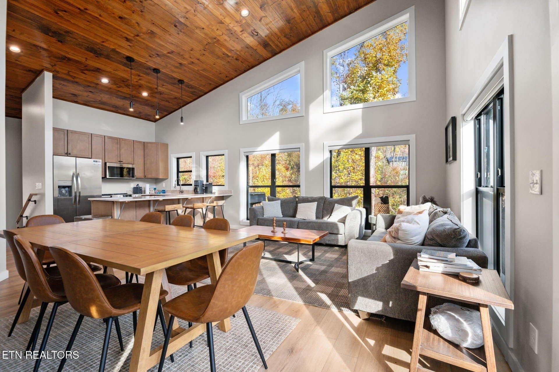 Gather around the table in this bright, open space where sunlight pours through tall windows and a stunning wood ceiling frames moments youll share together.