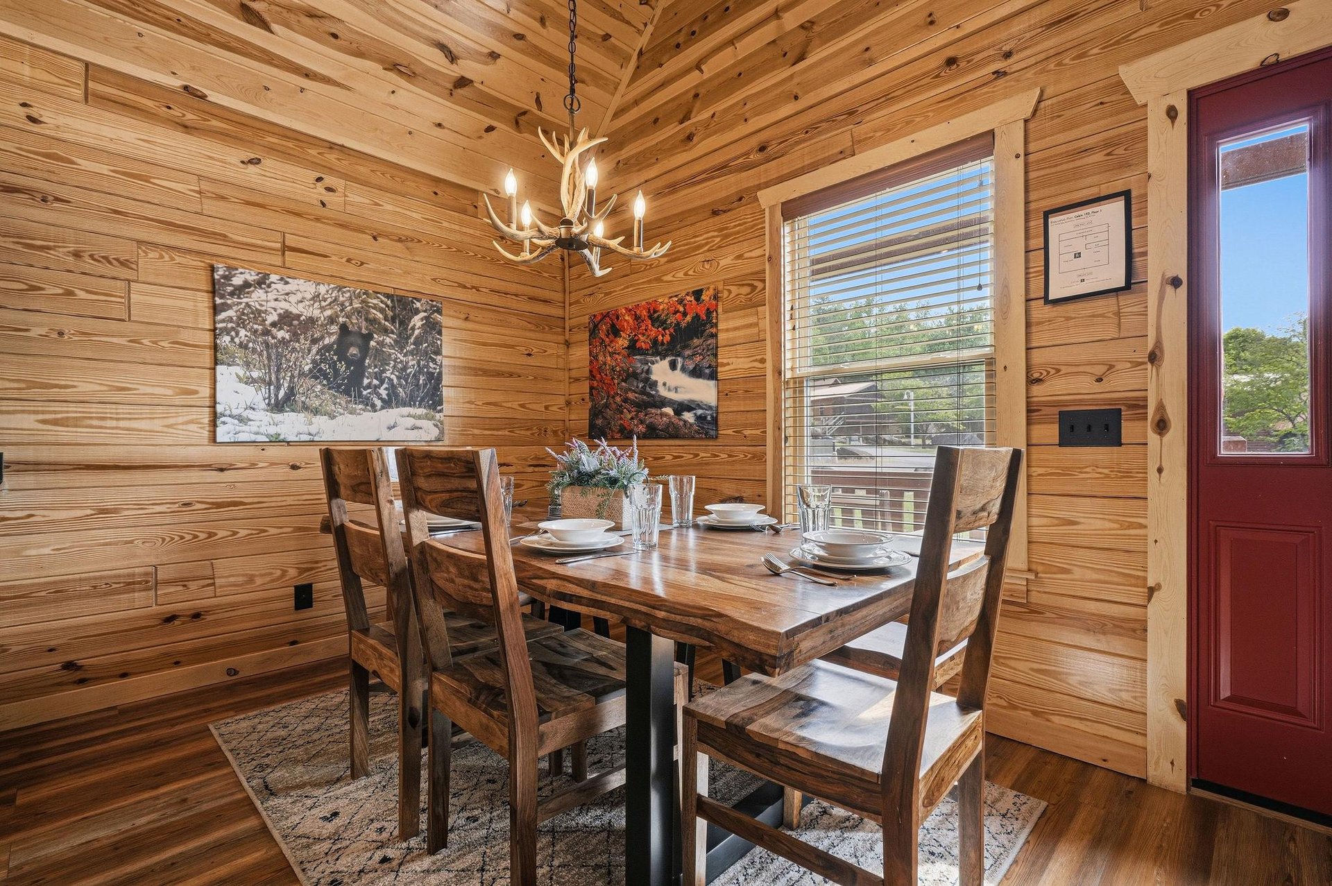 Gather around this handcrafted wooden table beneath a rustic antler chandelier—your group meals and game nights will feel warm and inviting in this charming cabin dining space.