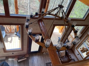 Soaring ceilings and a stunning chandelier create an impressive focal point in your living space, with natural light flooding through expansive windows.