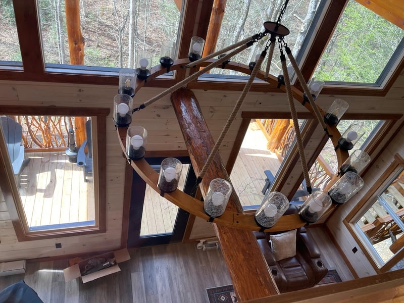 Soaring ceilings and a stunning chandelier create an impressive focal point in your living space, with natural light flooding through expansive windows.
