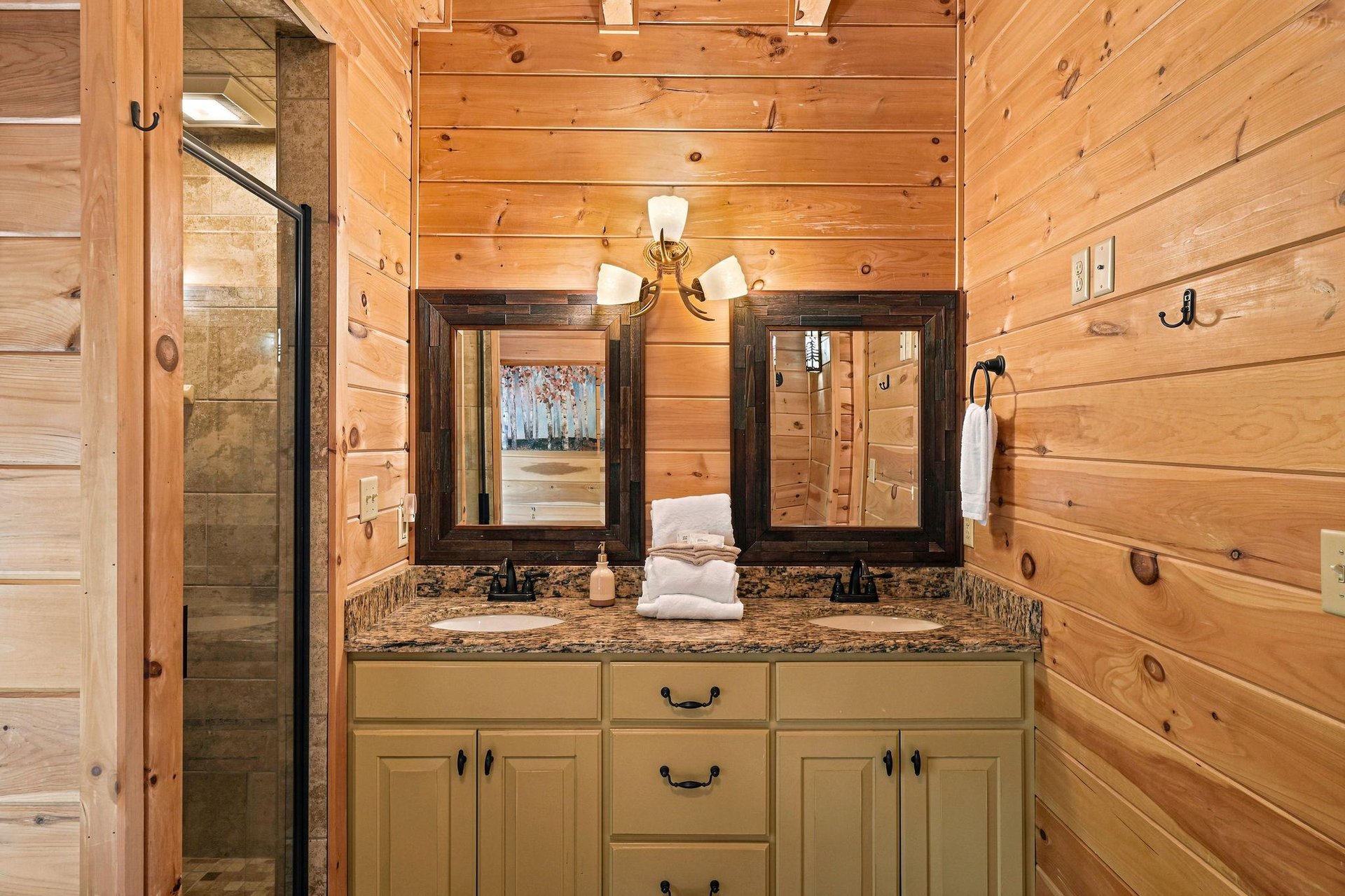Rustic charm meets modern comfort in your private bathroom, featuring warm wood walls, granite countertops, and a spacious walkin shower waiting to refresh you after a day of adventure.