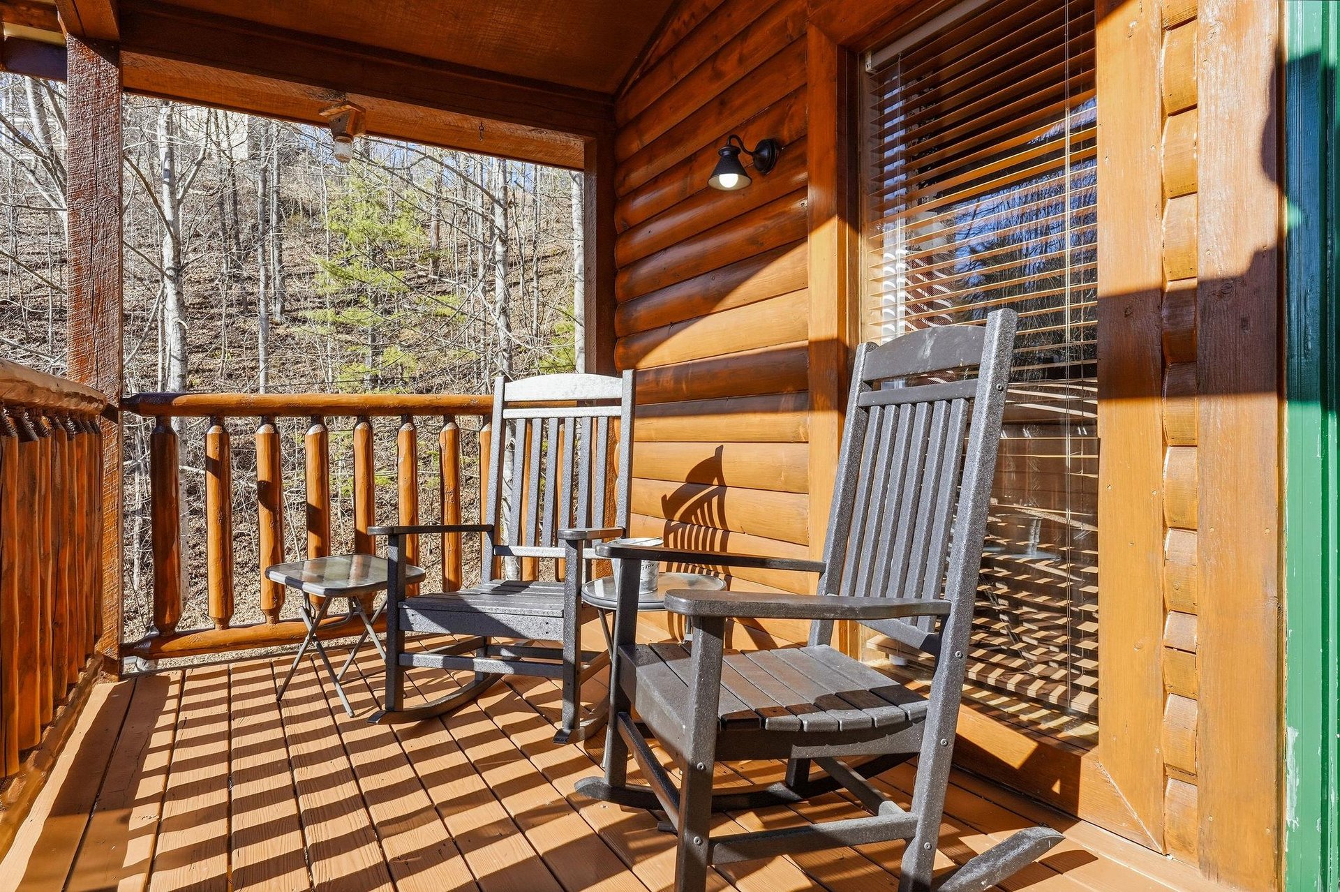 Unwind on your private covered deck with comfortable rocking chairs, surrounded by peaceful forest views and rustic cabin charm.