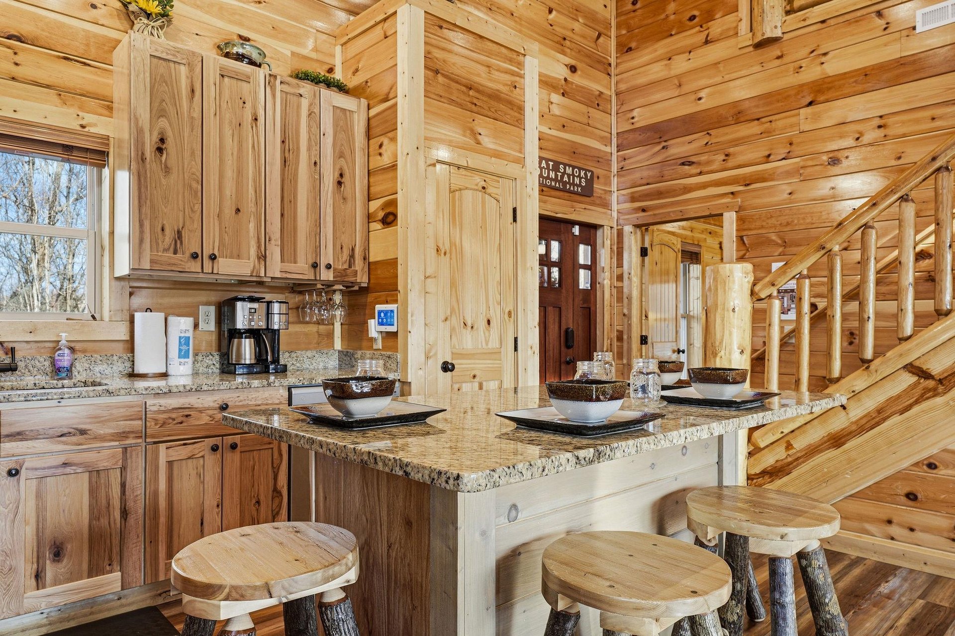 Your rustic kitchen features warm wood cabinetry, granite countertops, and charming log bar stools for cozy mountain mornings.