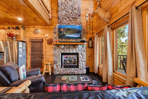 Sink into the cozy leather sofa, feel the warmth from your stone fireplace, and take in the forest through tall windows. Warm wood surrounds you—this cabin is your peaceful mountain escape.