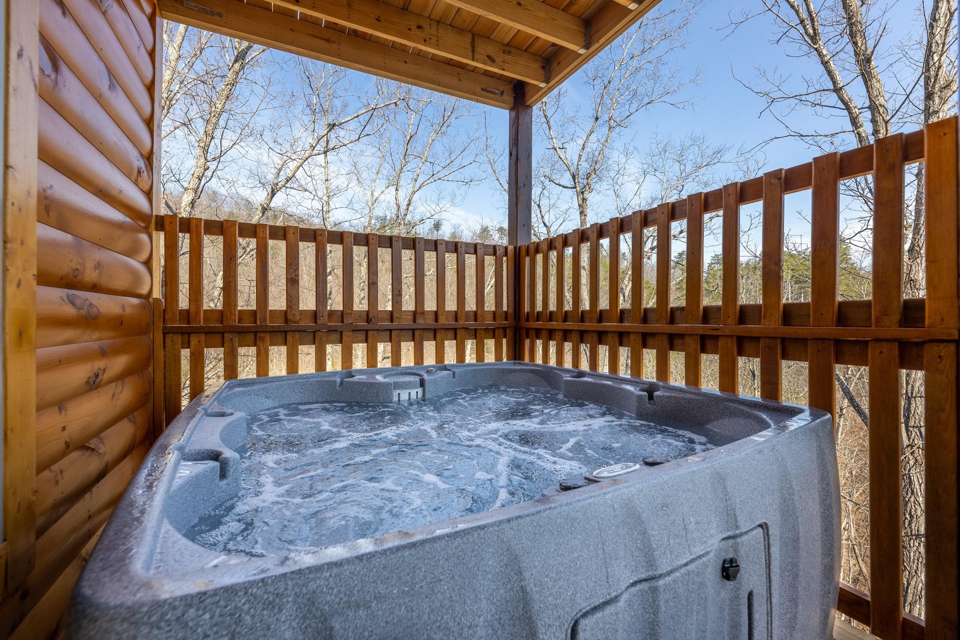 Hot tub on a covered deck at Everlys Splash, a 4 bedroom cabin rental located in Pigeon Forge