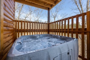 Hot tub on a covered deck at Everlys Splash, a 4 bedroom cabin rental located in Pigeon Forge