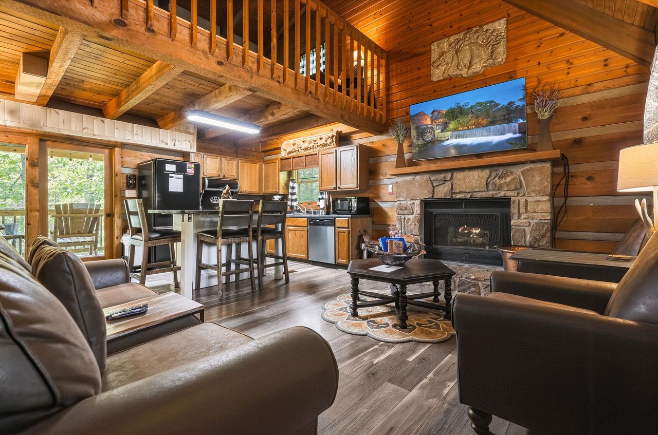 Relax in your spacious cabin with vaulted wood ceilings, a cozy stone fireplace, modern kitchen, and plush seating—perfect for unwinding after exploring the mountains.