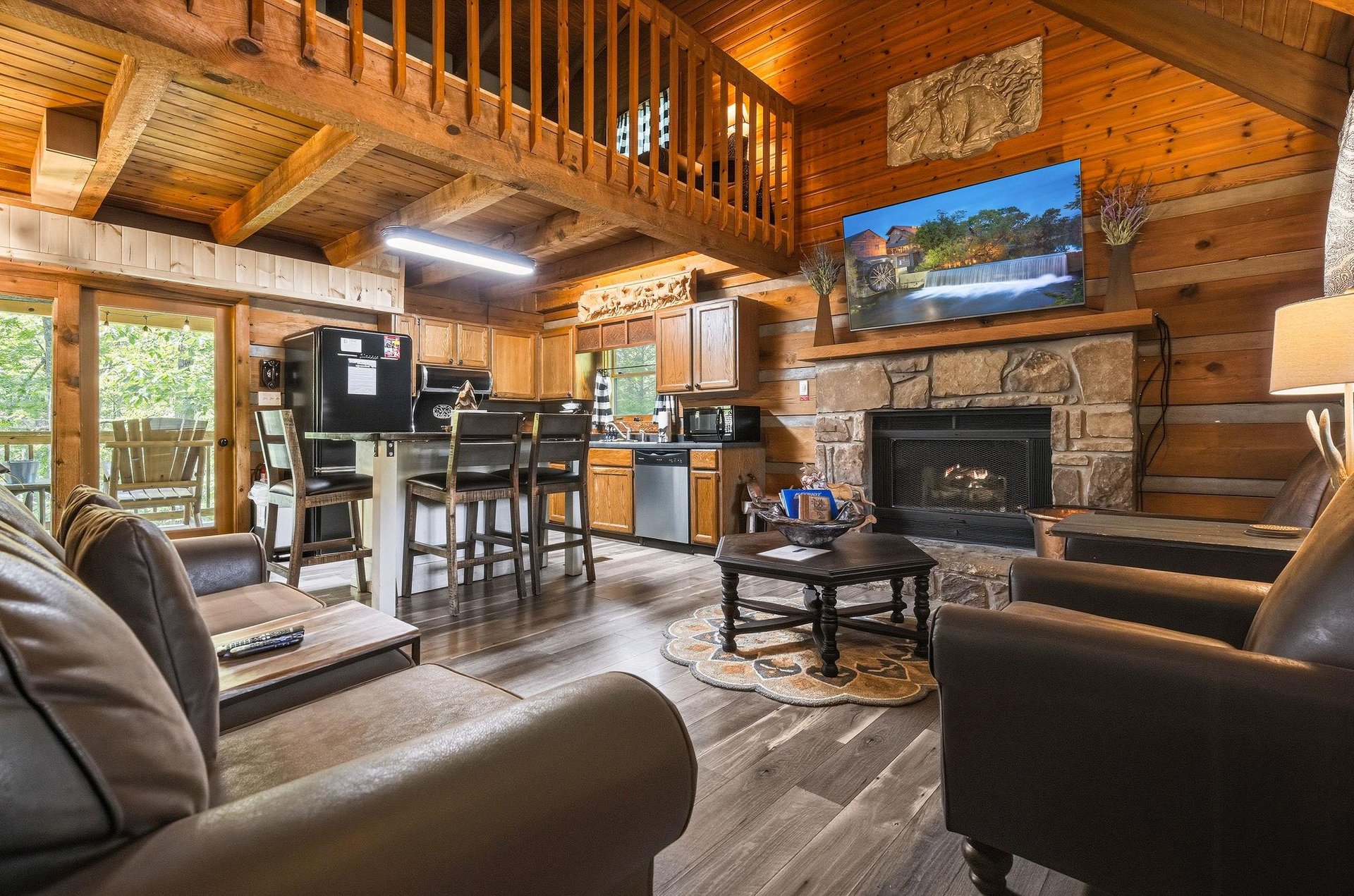 Relax in your spacious cabin with vaulted wood ceilings, a cozy stone fireplace, modern kitchen, and plush seating—perfect for unwinding after exploring the mountains.