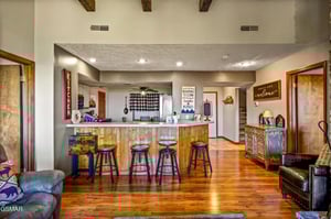 Gather around the rustic breakfast bar where wood beams frame your mountain retreats heart—perfect for morning coffee and evening conversations.