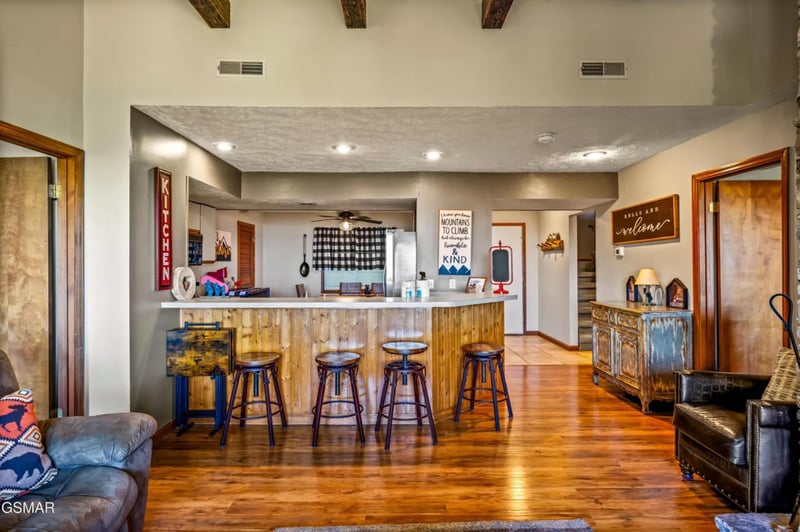 Gather around the rustic breakfast bar where wood beams frame your mountain retreats heart—perfect for morning coffee and evening conversations.