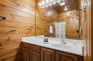 Step into your private bathroom, where warm wood walls create a cozy cabin feel. Crisp towels and thoughtful amenities await after your mountain adventures.