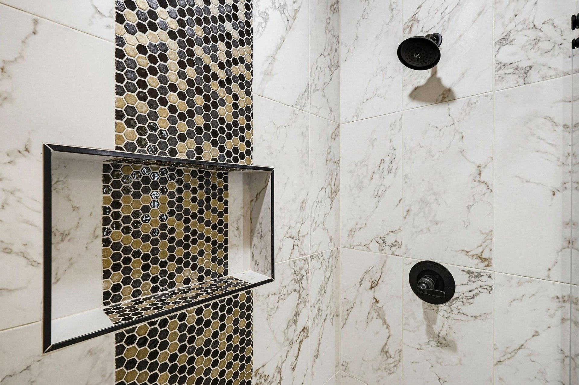 Elegant marble tile and honeycomb mosaic accent create a spainspired retreat in your private shower.