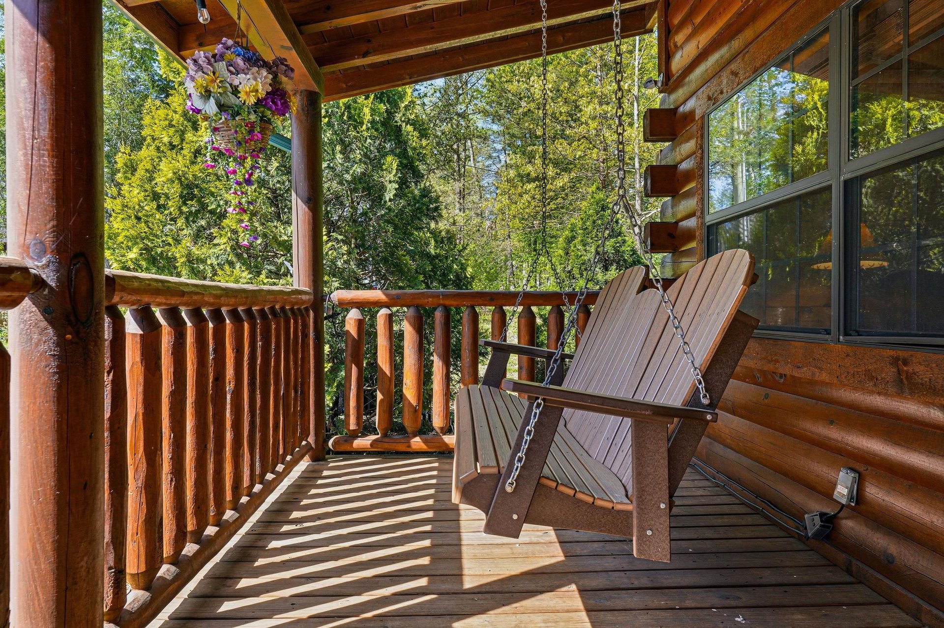 Swing gently on your private covered porch, surrounded by lush forest views and charming hanging baskets.