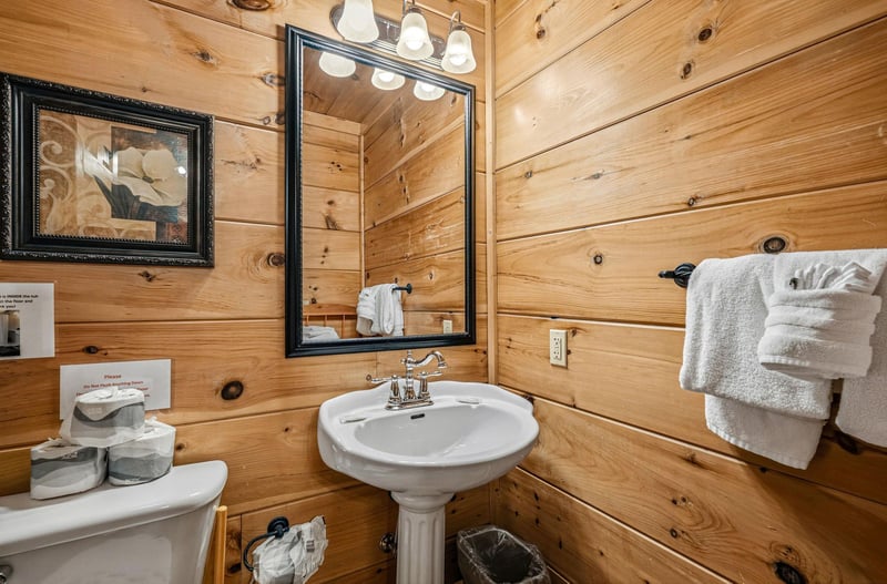 Step into your rustic log cabin bathroom, where warm wood walls and modern fixtures create the perfect mountain retreat atmosphere.