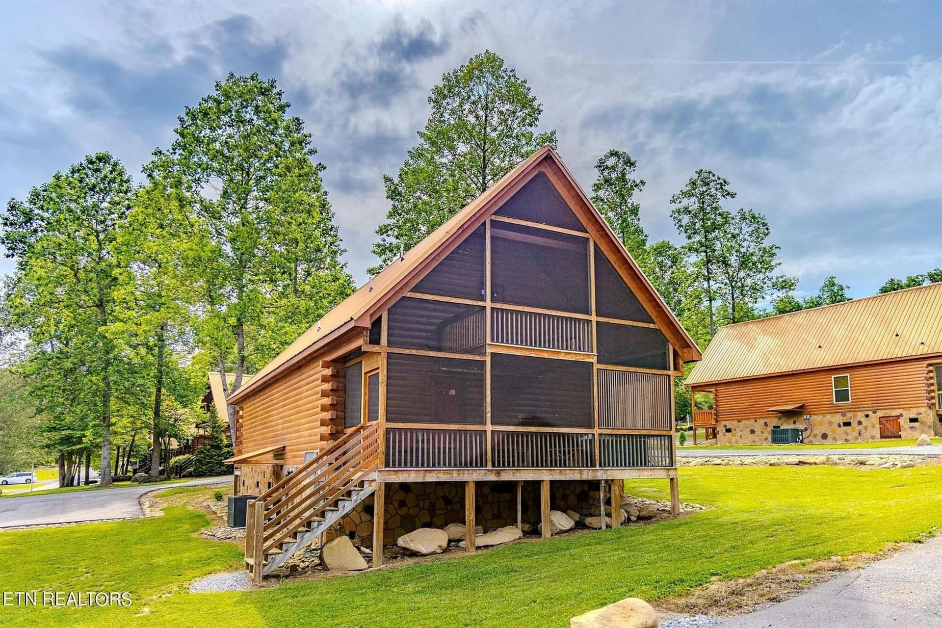 Charming log cabin nestled among towering trees with screened porch and peaceful wooded setting for your mountain getaway.