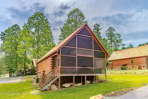 Charming log cabin nestled among towering trees with screened porch and peaceful wooded setting for your mountain getaway.