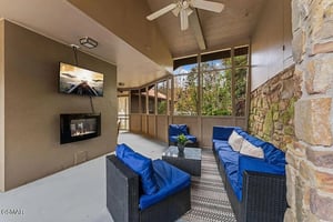 Unwind in your private screened patio with cozy seating, warming fireplace, and peaceful garden views.